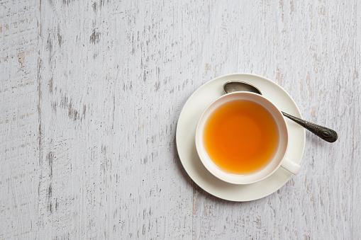 Taza de té con cuchara sobre fondo blanco photo