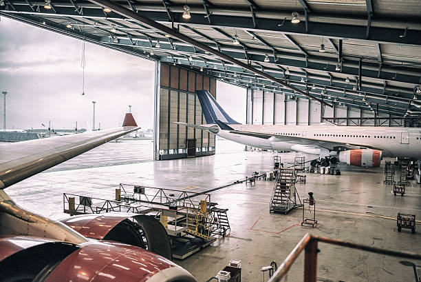 Aircrafts in hangar Two wide body aircrafts are parked and servicing in hangar. airplane hangar stock pictures, royalty-free photos & images