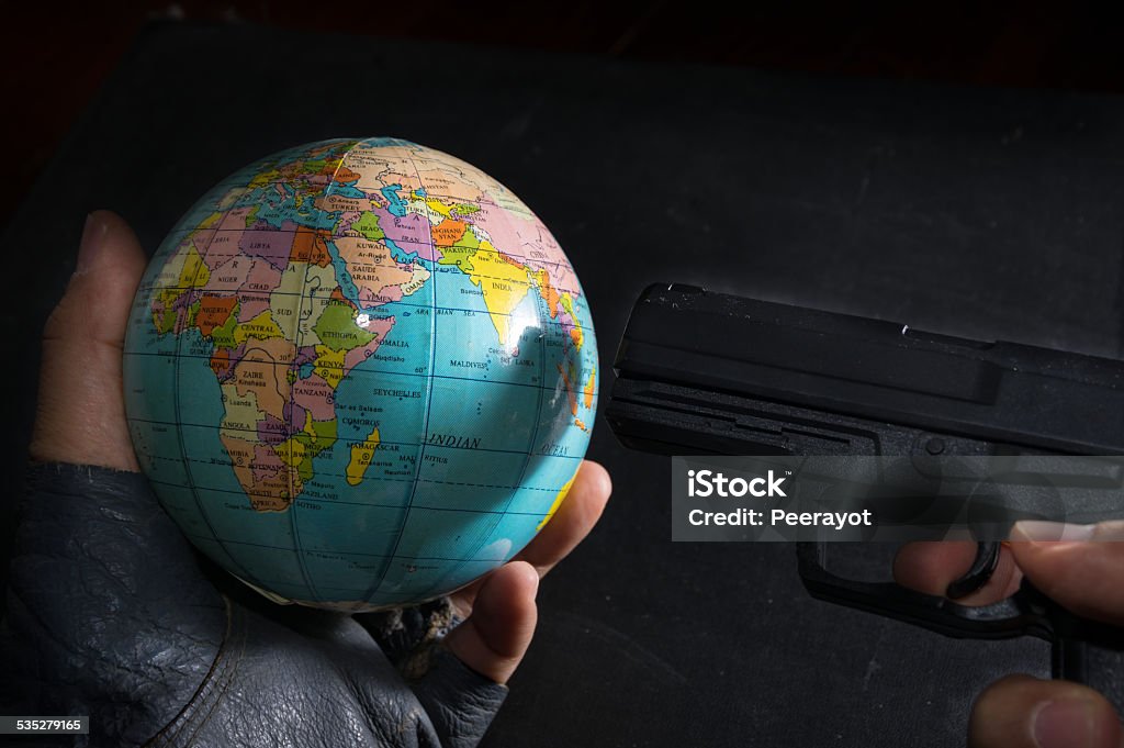 Terrorist put a gun to globe. Terrorist put a gun to globe,crime concept. 2015 Stock Photo