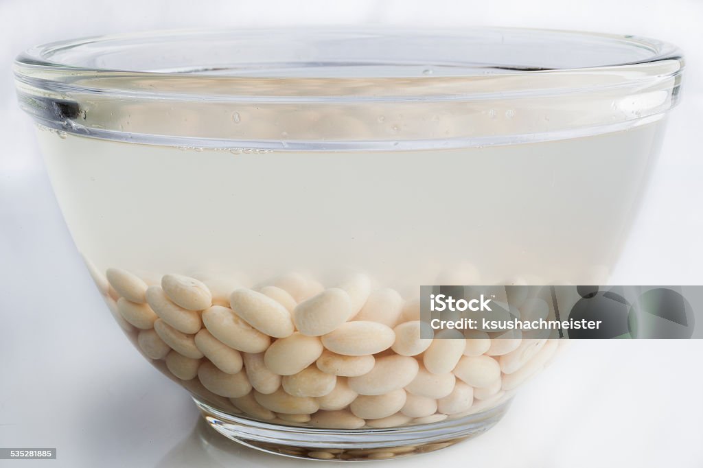 Soaked white beans on white White beans soaked in water in glass bowl on white background 2015 Stock Photo