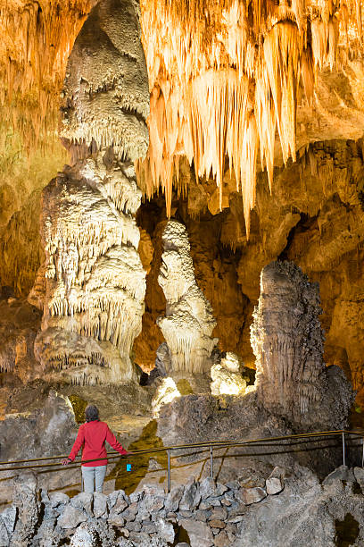 Tourist visiting Carlsbad Caverns National Park in New Mexico, USA. Woman looking at stalactites and stalagmites in cave.
