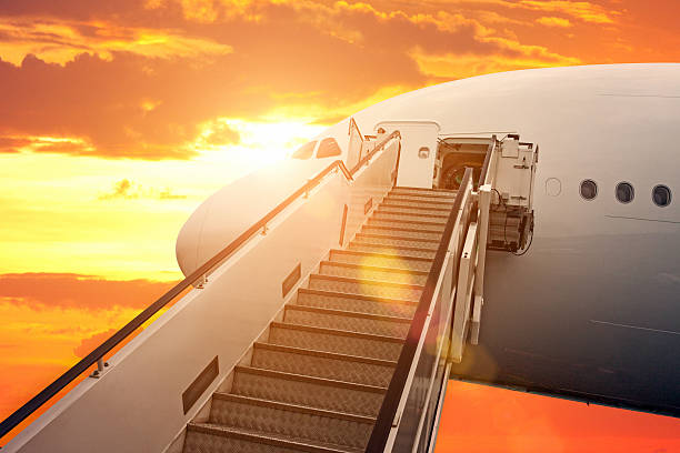 istock Jet airplane stairs at sunset with sun flares 535299131