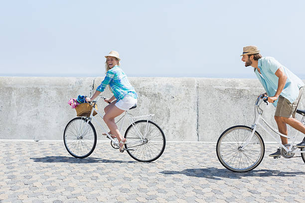 carino coppia su una bici da corsa - chasing women men couple foto e immagini stock