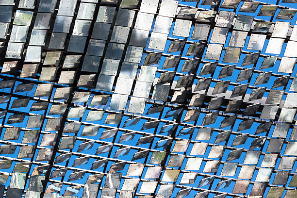 Low angle view of Heliostat motorised mirrors with reflection Low angle view of heliostat of motorised mirrors on high rise building Sydney Australia, full frame horizontal composition background with copy space  concentrated solar power photos stock pictures, royalty-free photos & images