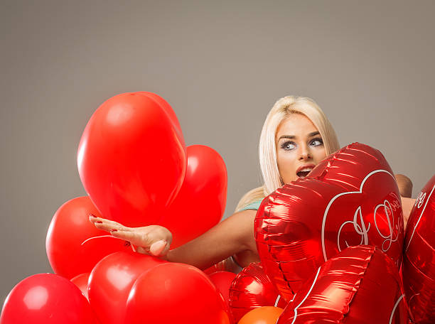 istock Blond surprised woman with red balloons heart 535300251
