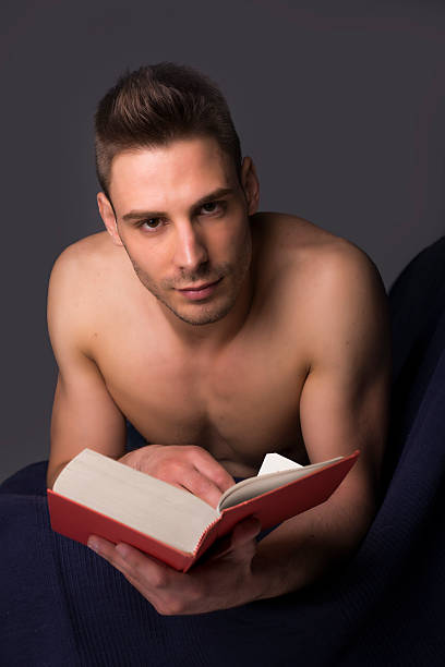 Hombre sin camisa joven atlético Lectura de libro mayor - foto de stock