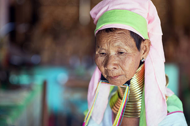 Faces of Myanmar Bagan, Myanmar - February 8, 2014: Portrait of long neck Kayan Lahwi woman with traditional headdress and brass coils around her neck. Brass coils creating long necks is a tradition of the Kayan Lahwi women. Myanmar is ethnically diverse with 51 million inhabitants belonging to 135 ethnic groups. kayan neck rings stock pictures, royalty-free photos & images