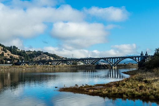 An arched bridge crosses the Rogue River in Gold Beach, Oregon.