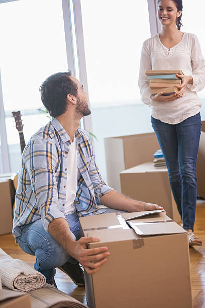 istock Smiling couple unpacking cardboard boxes 535334035