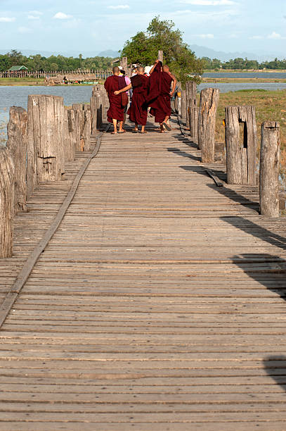 mönche, gehen zu fuß in der u-bein-brücke, myanmar. - ancient architecture buddhism burmese culture stock-fotos und bilder