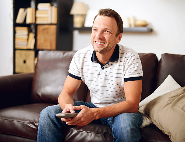 istock man in home interior Watching TV 535377615