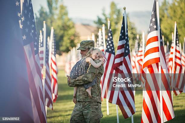 American Girl Hugging Her Dad In Front Of American Flags Stock Photo - Download Image Now
