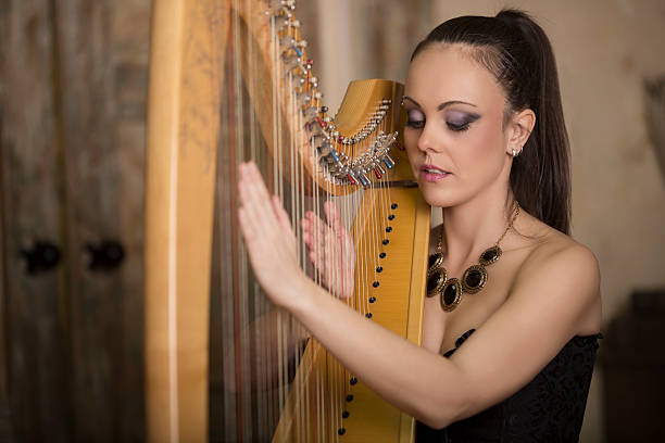 istock woman playing the harp 535400479