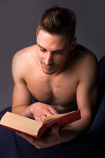 Hombre sin camisa joven atlético Lectura de libro mayor - foto de stock