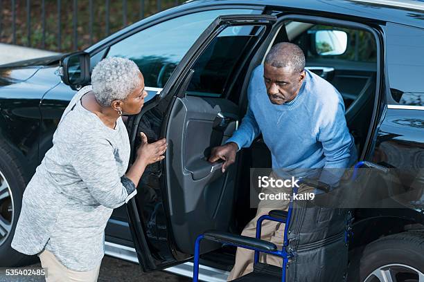 Senior Woman Helping Disabled Husband Out Of Car Stock Photo - Download Image Now - Car, Mode of Transport, Senior Adult