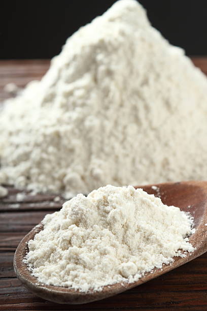 istock Wooden spoon with wheat flour on plank table 535402680