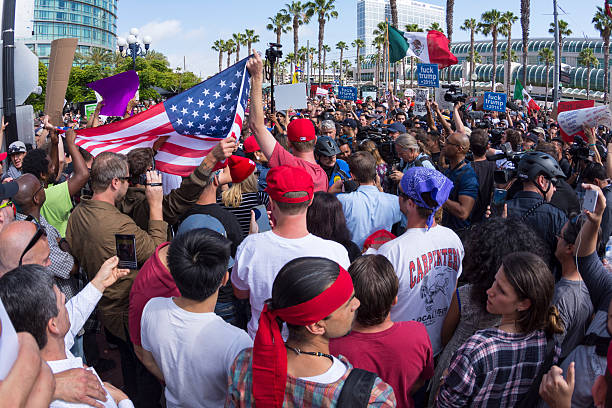 Protesters peacefully face off at Trump rally San Diego, California, USA - May 27, 2016: Tensions rise as anti-Trump protesters meet Trump supporters and American and Mexican flags are held up representing each group at a Donald Trump rally at the San Diego Convention Center. political rally stock pictures, royalty-free photos & images