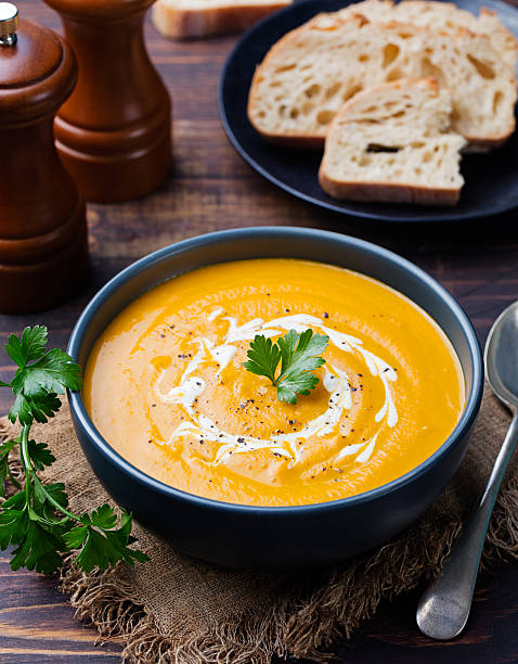istock Pumpkin and carrot soup with cream and parsley 535406014