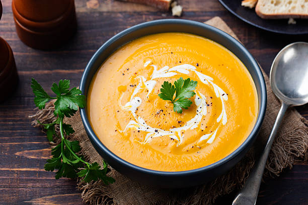 istock Pumpkin and carrot soup with cream and parsley 535406090