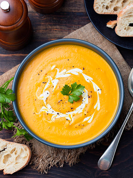 istock Pumpkin and carrot soup with cream and parsley 535406230