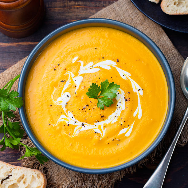 istock Pumpkin and carrot soup with cream and parsley 535406314
