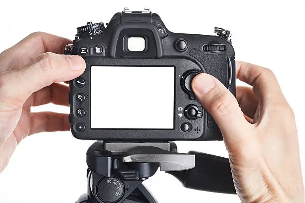 Hands photographer adjust SLR camera isolated on white