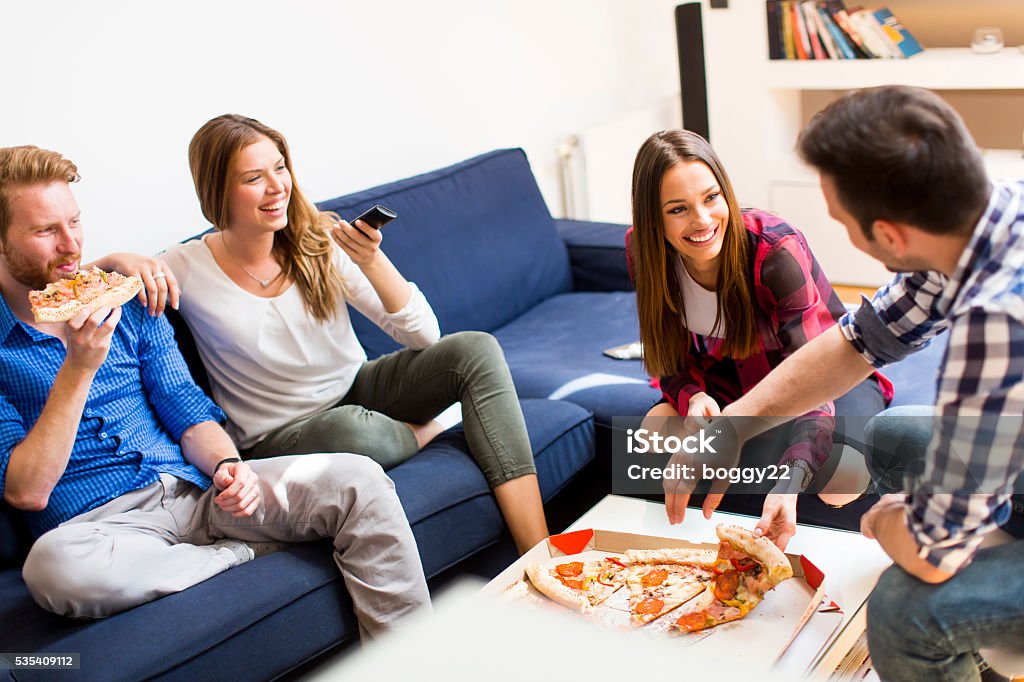 Friends eating pizza Group of friends eating pizza together at home Adult Stock Photo