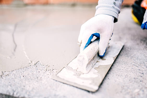 industrial worker on construction site laying sealant for waterproofing cement stock photo