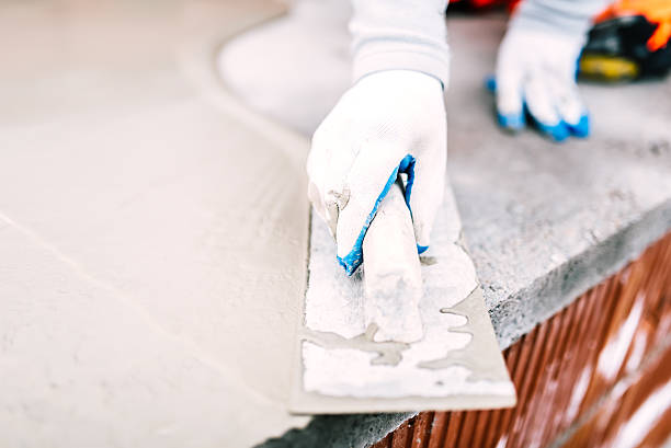 istock close-up of worker steel trowel and hand, using plastering tools 535412054