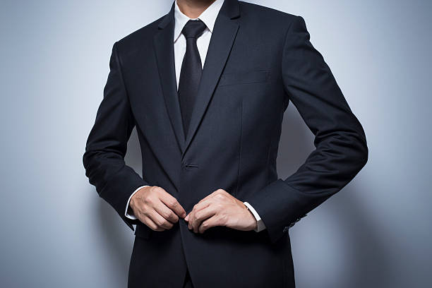 Businessman Dressing Up a Black Suit Businessman Dressing Up a Black Suit necktie fashion adjusting suit stock pictures, royalty-free photos & images