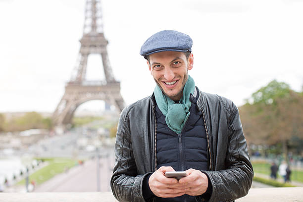 istock Young man using a smart phone near the eiffel tower 535412322