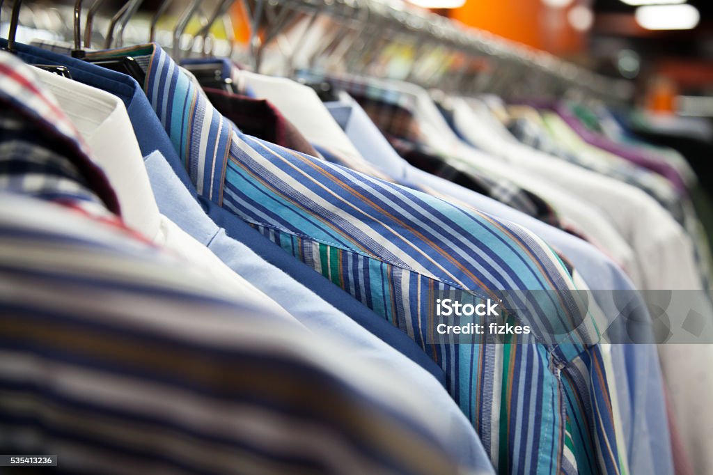 Collection of male shirts on rack Hangers with colorful male shirts in fashion mall, close up. Shallow depth of field, focus on striped garment Adult Stock Photo
