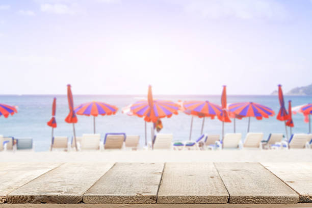 istock wooden desk on beach side. rusty pink background color 535413978