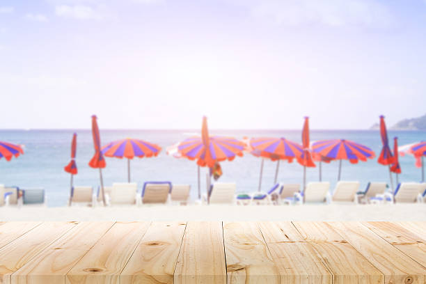 istock wooden desk on beach side. rusty pink background color 535413992