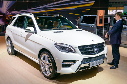 Brussels, Belgium - January 15, 2015: Mercedes Benz M-class ML 250 BlueTec SUV on display during the 2015 Brussels motor show. People in the background are looking at the cars.