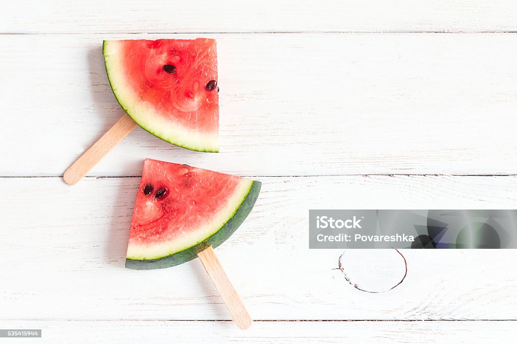 watermelon slices on sticks on wooden white background Summer Stock Photo
