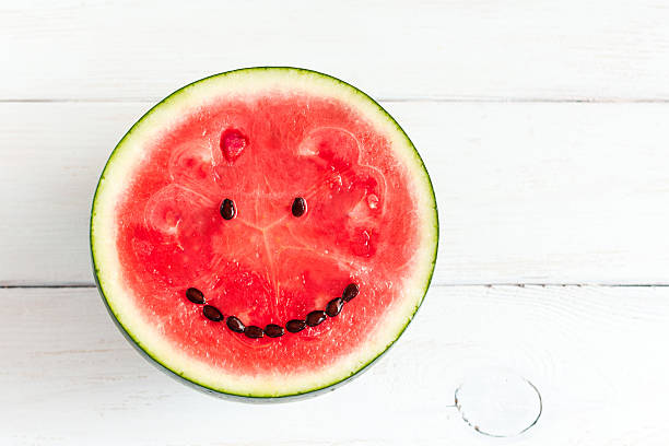 pastèque avec sourire sur fond de bois blanc - watermelon fruit food portion photos et images de collection