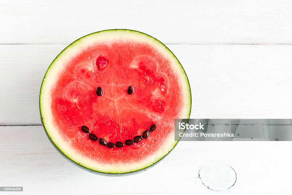 watermelon with smile on white wooden background Watermelon Stock Photo