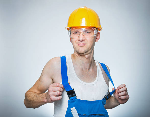 Funny lazy builder Funny lazy builder, isolated on gray. Studio shot, close up lazy construction laborer stock pictures, royalty-free photos & images
