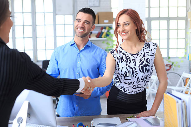 istock Smiling young couple making a deal with agent 535417774