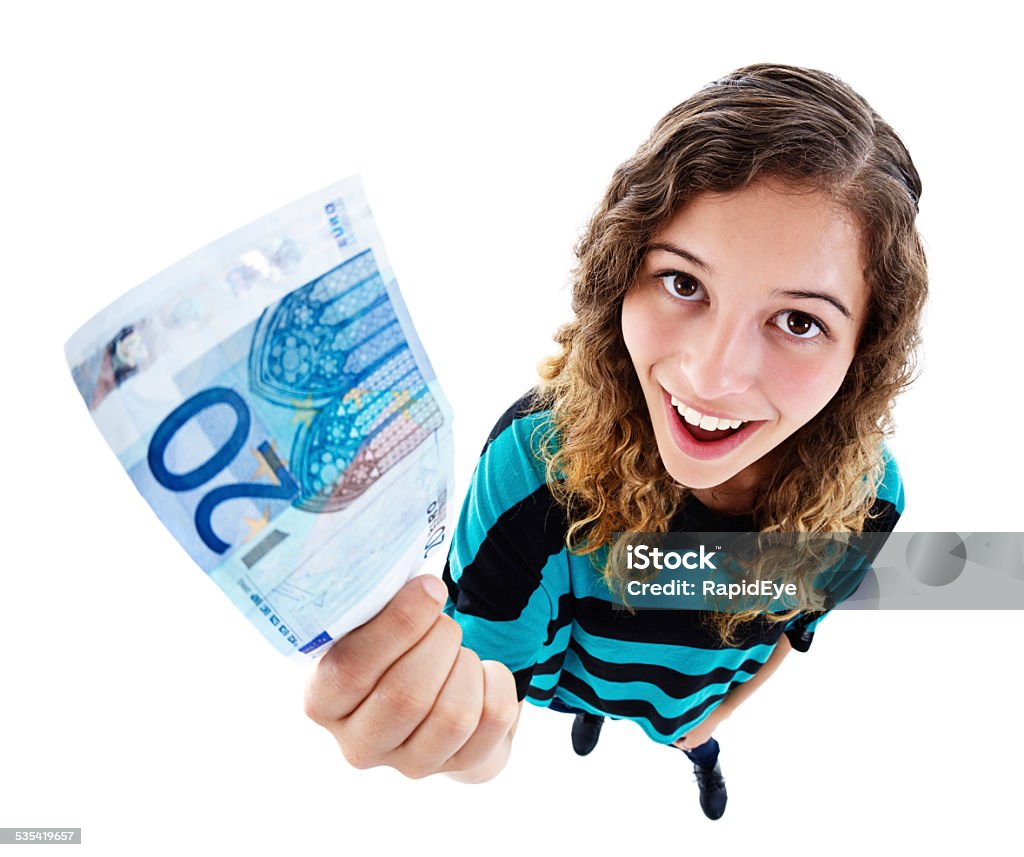 Delighted young cutie holding up 20 Euro banknote. High-angle view. An exaggerated high-angle view of a delighted and beautiful young woman looking up, smiling and holding up a 20 Euro note. Isolated on white. Fish-eye lens exaggerates the perspective. Twenty Euro Banknote Stock Photo