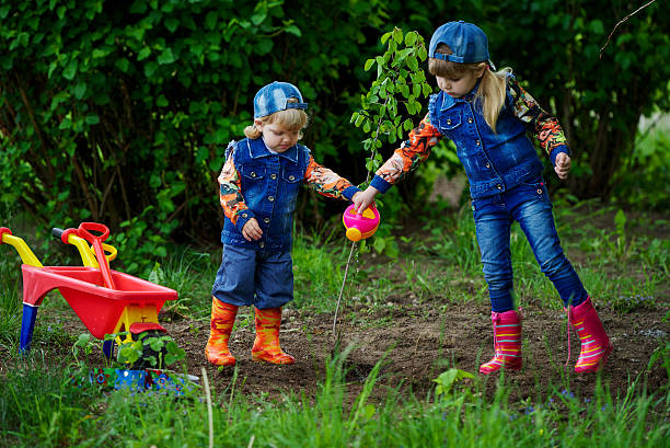 istock happy girls planting tree 535423658