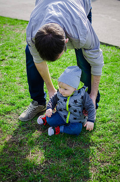 istock Father raises his son who fell making first steps 535424824