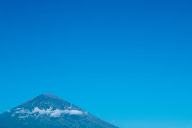 The volcano Gunung Agung dominating the horizon taken from Amed against a clear blue sky, a little fishing village located on the east coast of Bali, Indonesia.