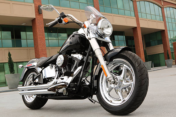 Custom Harley Motorcycle parked outside an office complex Elmwood Park New Jersey, USA - May 22, 2016: This Harley Fat Boy is parked outside an office complex main lot. Harley Davidson continues to be the premier brand of motorcycle in the world.	 harley davidson fat boy stock pictures, royalty-free photos & images