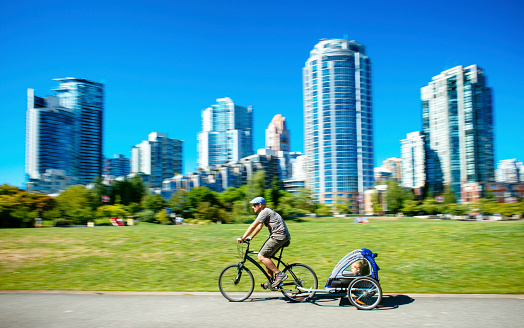 Father carries son in bicycle trailer in Vancouver. Canada.