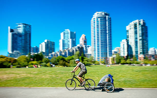 ojciec daje syn na rowerze przyczepy w vancouver kanada - parks canada zdjęcia i obrazy z banku zdjęć