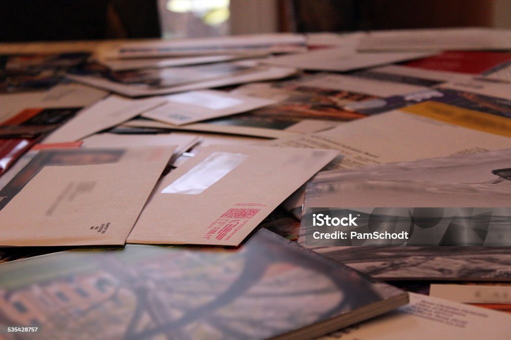 Table Covered with Junk Mail Envelopes This table is covered with mail envelopes and solicitations. Identifiers have been blurred out. Junk Mail Stock Photo