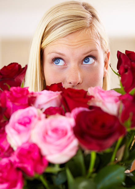 Floral elegance, blooming beauty, joyful celebration. Beautiful woman with blonde hairstyle and blue eyes, natural makeup, holding a bouquet of pink roses
