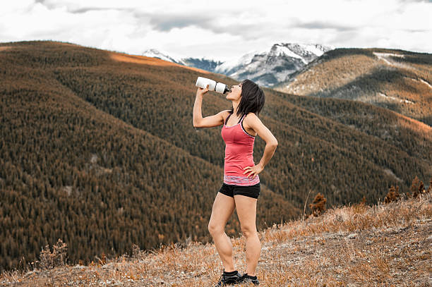 istock Asian Woman Relaxes and Drinks Water While Wilderness Hiking. 535431651